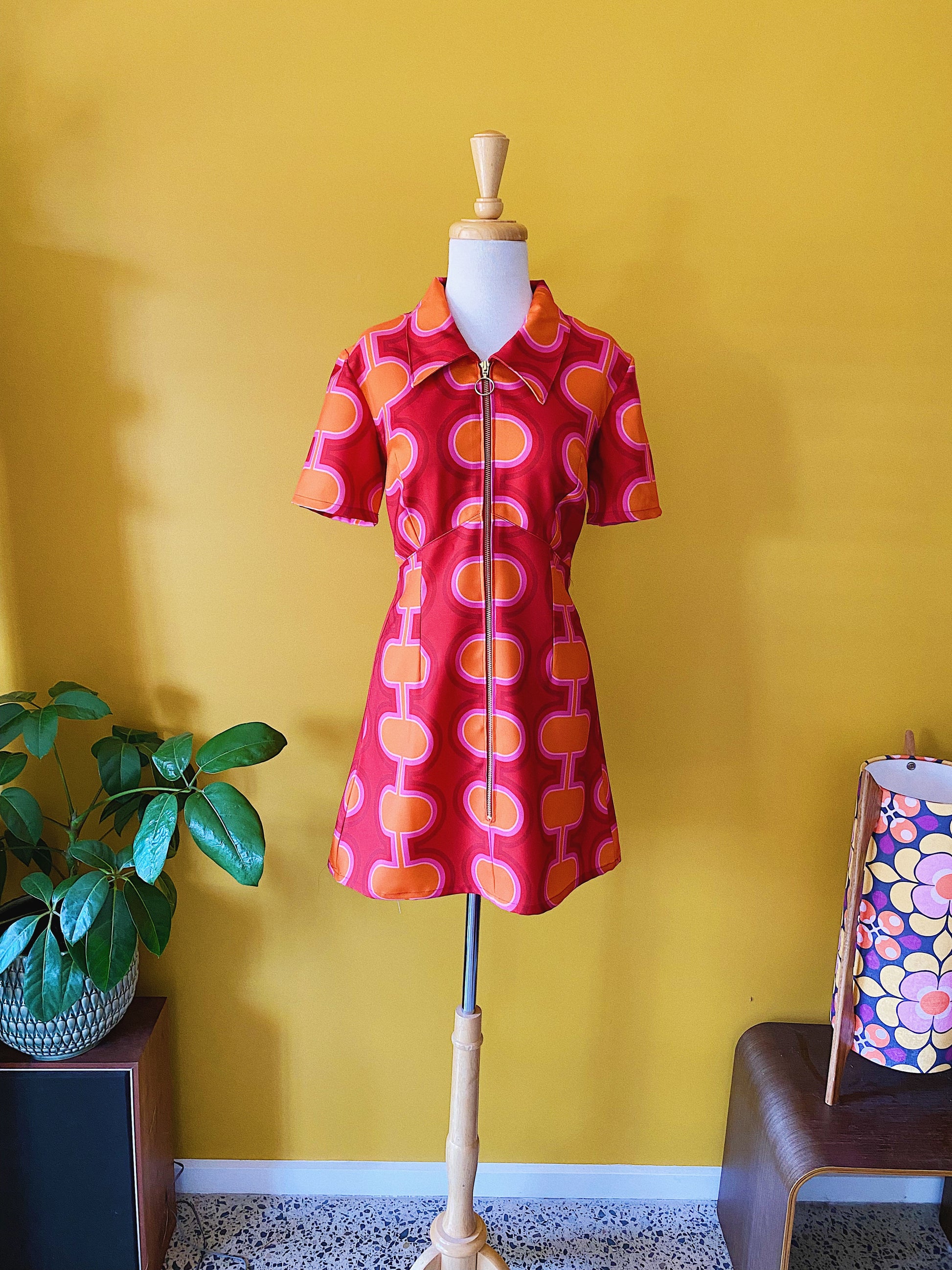 Short sleeve mini dress in retro 1960's 1980's red pink and orange print with gold zip and pointed collar.
