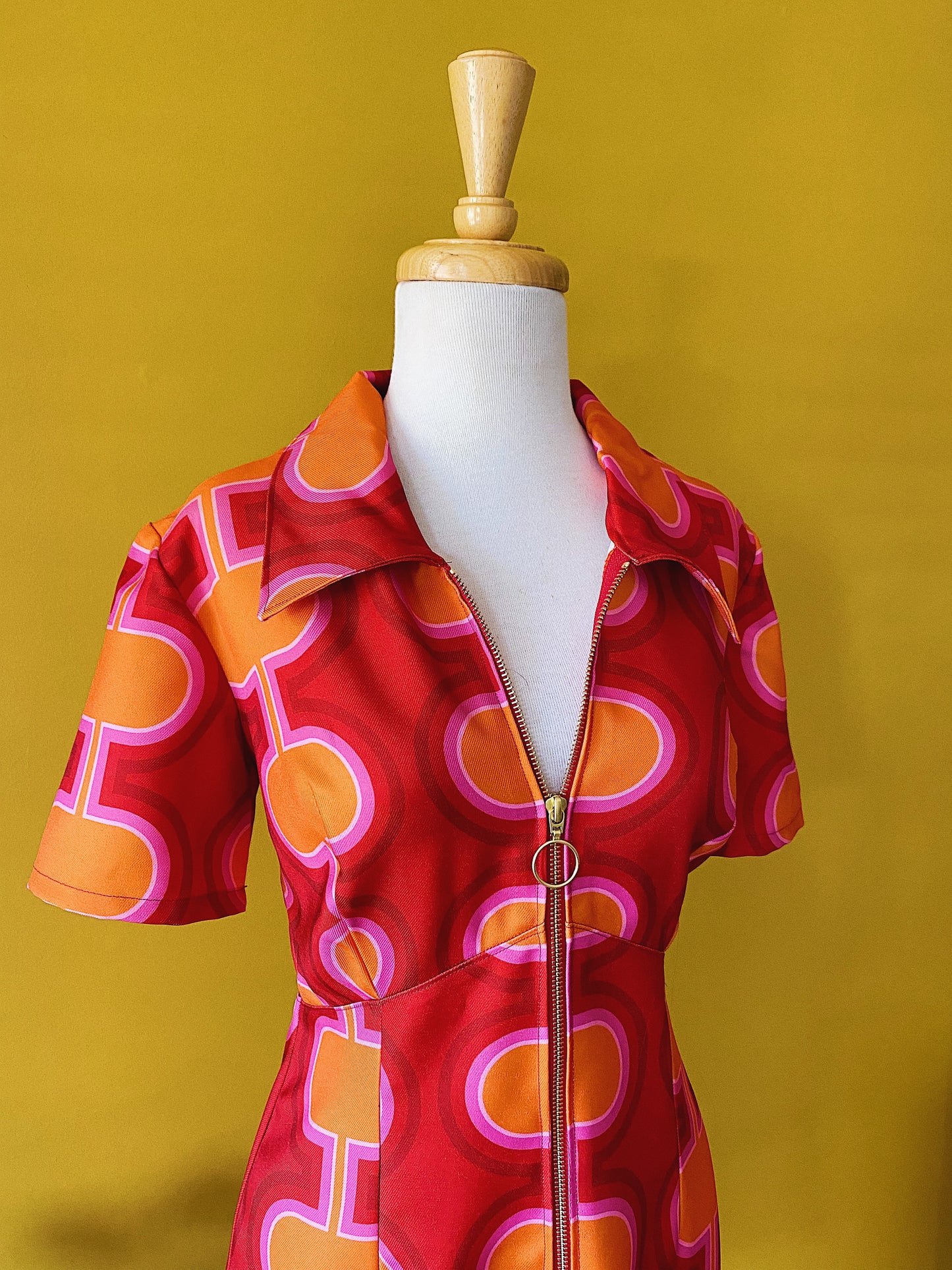 Short sleeve mini dress in retro 1960's 1980's red pink and orange print with gold zip and pointed collar.